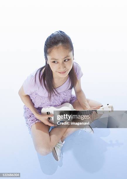 young woman playing the ukulele - skirt isolated stock pictures, royalty-free photos & images