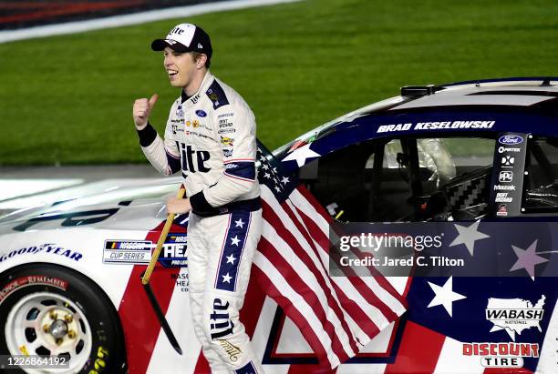 Brad Keselowski, driver of the Miller Lite Ford, celebrates with the American flag after winning the NASCAR Cup Series Coca-Cola 600 at Charlotte...