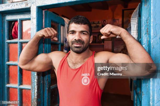 indian wrestler showing muscles new delhi india - bodybuilder flexing biceps stock pictures, royalty-free photos & images