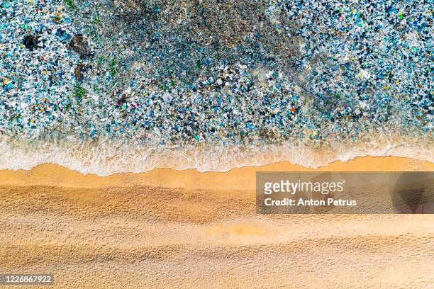 beach with garbage in the water. ocean pollution concept with plastic and garbage - landfill stock-fotos und bilder