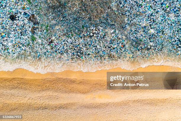 beach with garbage in the water. ocean pollution concept with plastic and garbage - plastic pollution stock pictures, royalty-free photos & images