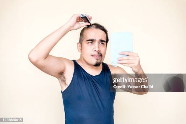 a man doing own haircuts - halved stock-fotos und bilder
