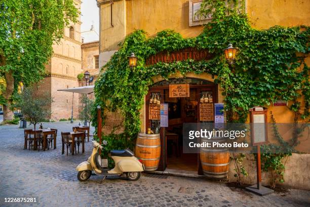 a lovely vintage vespa in front of a typical restaurant in trastevere in the historic heart of rome - italia stock pictures, royalty-free photos & images
