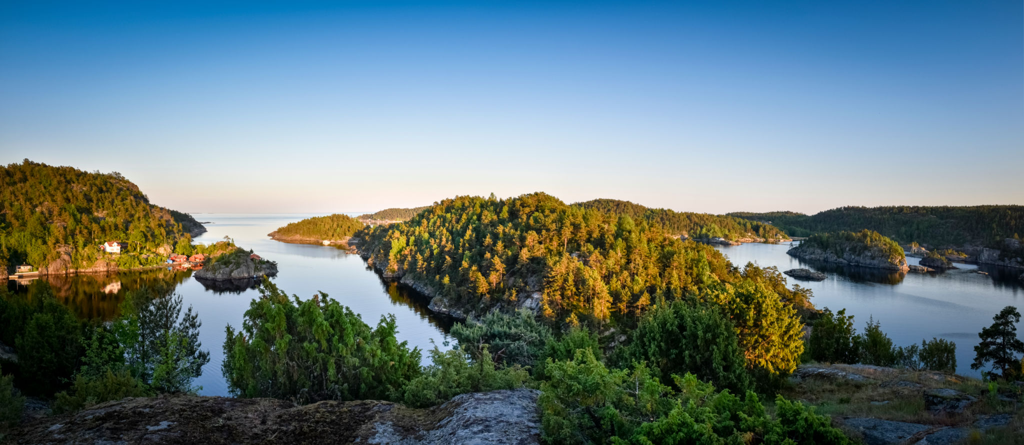 Panorama of the Norwegian coastline bay with lots of green forest at dusk Panorama of the Norwegian coastline bay with lots of green forest at dusk