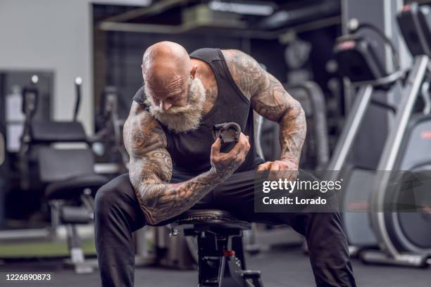 tatuerade senior man under gym workout - shaved head bildbanksfoton och bilder