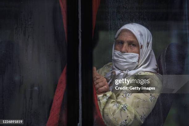 Bosnian Muslim woman looks from the bus taking relatives of victims of Srebrenica genocide to visit sites of 1995 mass execution of their loved ones,...