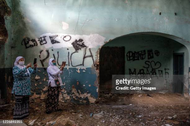 Serb nationalist graffiti are seen inside a culture house as relatives of victims of Srebrenica genocide visit sites of 1995 mass execution of their...