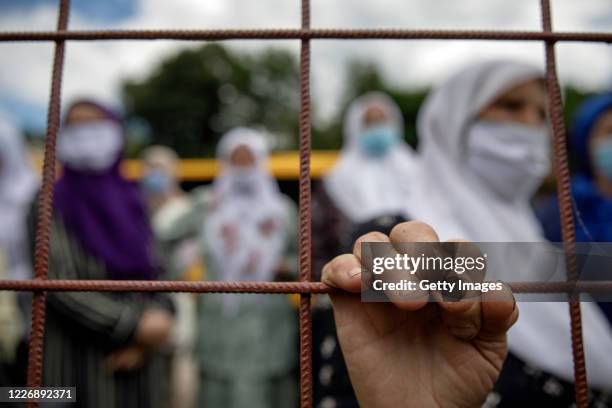 Bosnian Muslim woman, relatives of victims of Srebrenica genocide, visit one of the sites of 1995 mass execution of their loved ones, on July 13,...