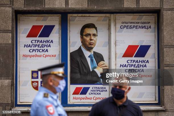 Security personnel stand in front of a picture of Serbian president Aleksandar Vucic decorating building of former police station, now headquarters...