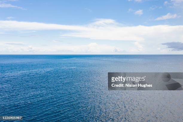 aerial flying over the ocean looking at the clear horizon in the distance - horizont stock-fotos und bilder