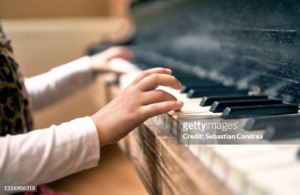 little girl  playing the piano with her little fingers. - keyboard musical instrument child stock-fotos und bilder