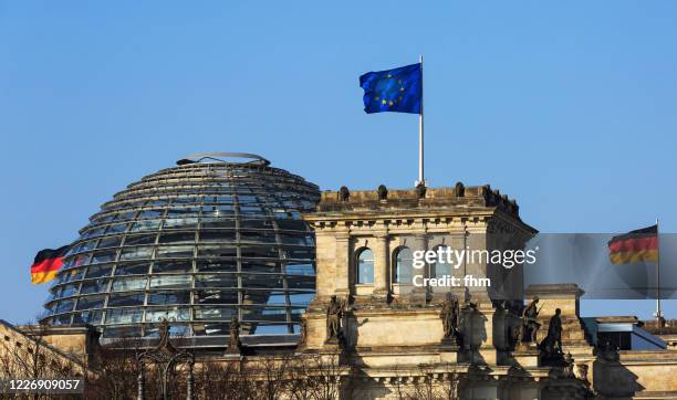 reichstag dome with german and eu-flag - berlin, germany - kuppeldach oder kuppel stock-fotos und bilder