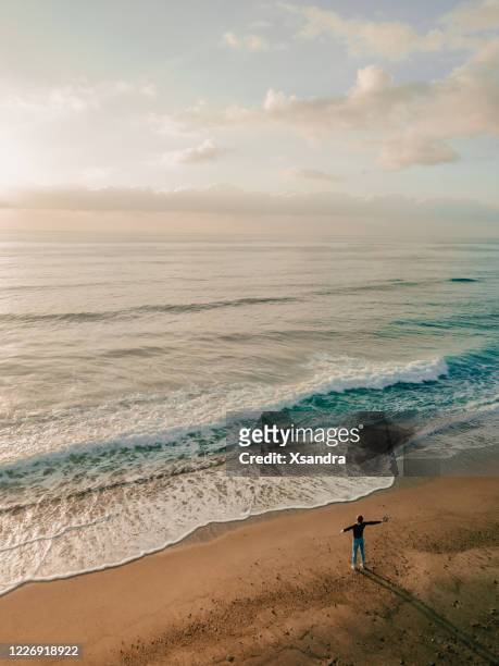 woman standing on the beach - watching sunrise stock pictures, royalty-free photos & images