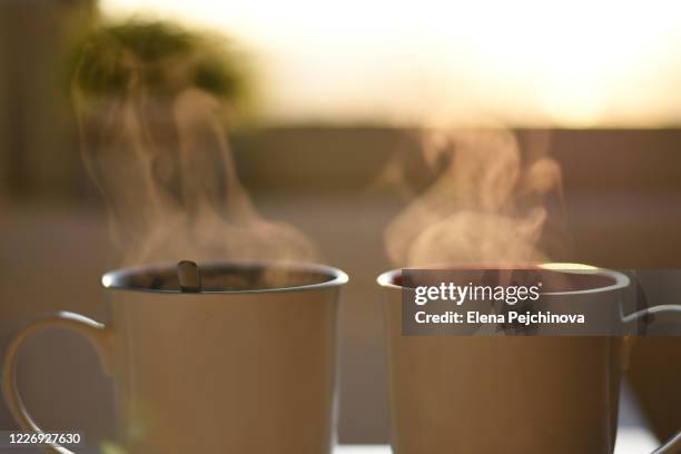 two cups of hot steaming coffee - tea for two stock-fotos und bilder