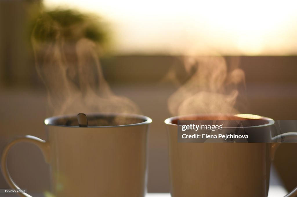 Two cups of hot steaming coffee