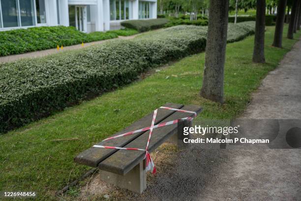 park bench closed off to assist social distancing during coronavirus pandemic. - coronavirus england stock pictures, royalty-free photos & images