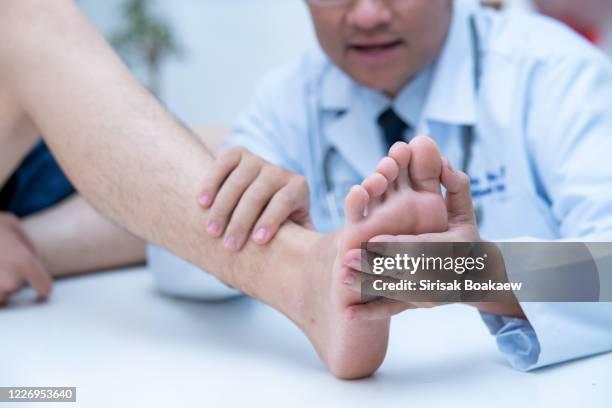 the doctor is examining the patient's feet doctor dermatologist - nails imagens e fotografias de stock