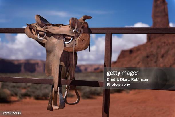 saddle resting on a fence in monument valley, arizona - saddle stock pictures, royalty-free photos & images