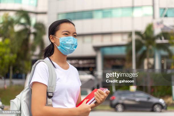 young female student going to school wearing protective facemask - malaysia school stock pictures, royalty-free photos & images