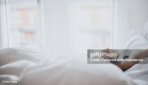 joyful girl lying on bed - quilt imagens e fotografias de stock