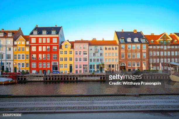 colorful vibrant houses at nyhavn harbor in copenhagen, denmark - copenhagen stock-fotos und bilder