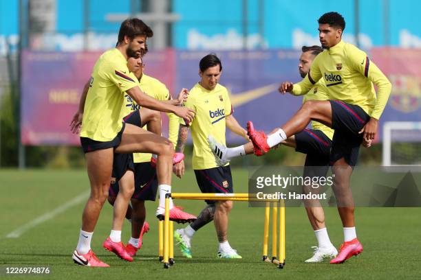In this handout image provided by FC Barcelona Lionel Messi of FC Barcelona exercises with teammates Jordi Alba , Junior Firpo , Arturo Vidal and...