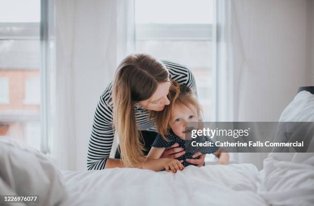 woman and little girl - confort at hotel bedroom ストックフォトと画像