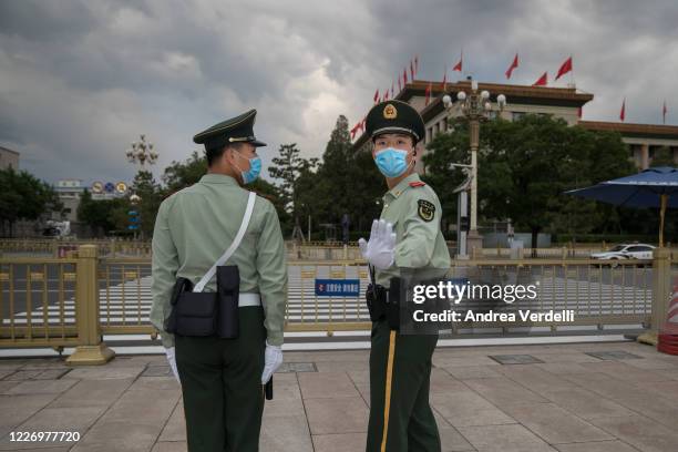 Soldiers of the People's Liberation Army stop the photojournalist from shooting in Tiananmen Square at the end of the Second Plenary Meeting of the...