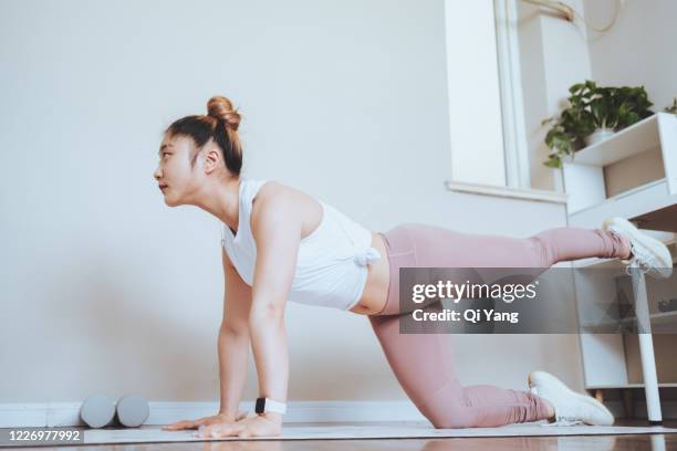 beautiful young woman practicing yoga at home - pilates home stock pictures, royalty-free photos & images