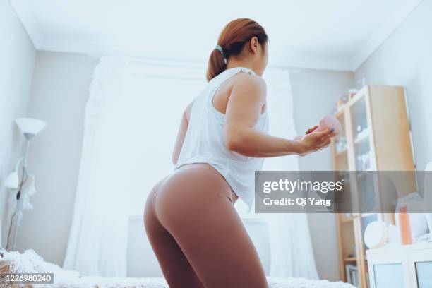 young woman exercising with dumbbells at home - beautiful bums imagens e fotografias de stock