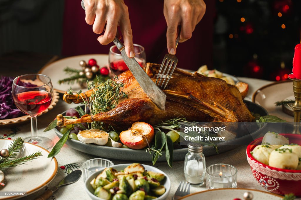 Woman Serving Roast Duck For Christmas Dinner High-Res Stock Photo