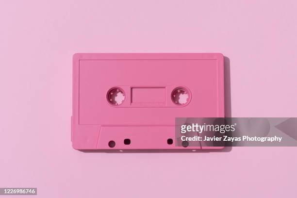 pink cassette tape on pink background - musica pop foto e immagini stock