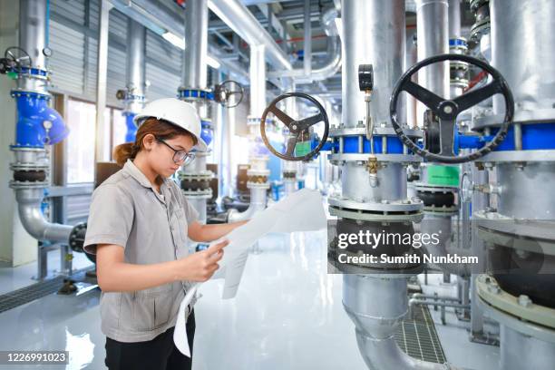 young woman mechanical engineer holding drawing to checking and inspection of hvac heating ventilation air conditioning system on pressure gauge of industrial air compressor boiler pump room system in the factory - compressor stockfoto's en -beelden