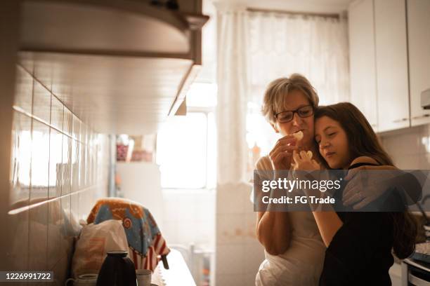 granddaughter and grandmother having a breakfast at home - pão de queijo stock pictures, royalty-free photos & images