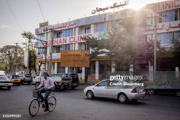 Cyclist wearing a protective mask rides past the Subhan Clinic, which the Afghanistan health ministry closed down for selling an anti-coronavirus...