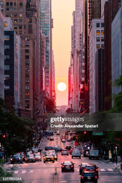 manhattanhenge seen from 42nd street in new york city, usa - 42nd street stock-fotos und bilder