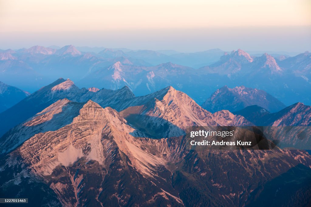 Blick bei Sonnenaufgang auf die umliegende Berge von der Zugspitze in Deutschland