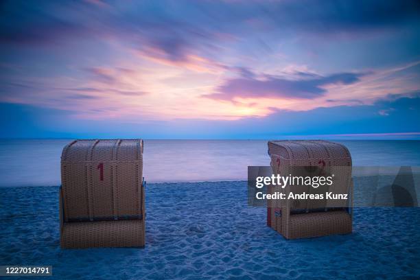 strandkörbe bei sonnenuntergang bei timmendorf strand auf insel poel in deutschland - poel island stock pictures, royalty-free photos & images