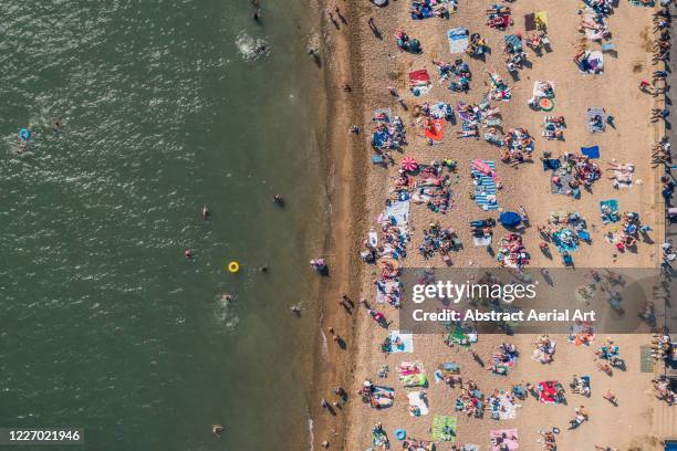 aerial view showing a crowd of people sunbathing on a beach, southend-on-sea, essex, united kingdom - crowded beach stock pictures, royalty-free photos & images