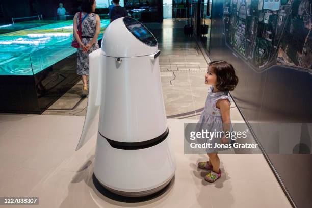 Young girl communicating with a robot that is on display at Incheon International Airport in Seoul / South Korea. The Guide Robot recognises...