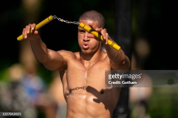 Man practices with nunchucks in Washington Square Park during the coronavirus pandemic on May 25, 2020 in New York City. Government guidelines...