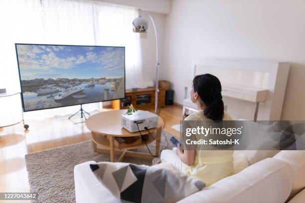 mujer viendo película según la pantalla del proyector en la sala de estar - cinema screen fotografías e imágenes de stock