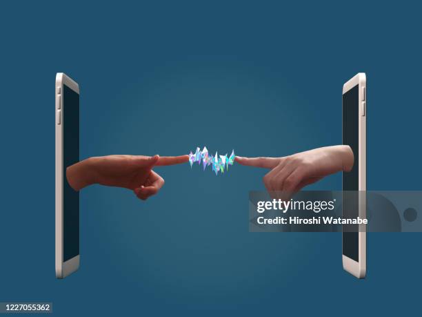 two hands are connecting from smartphone with light trails - image manipulation stock pictures, royalty-free photos & images