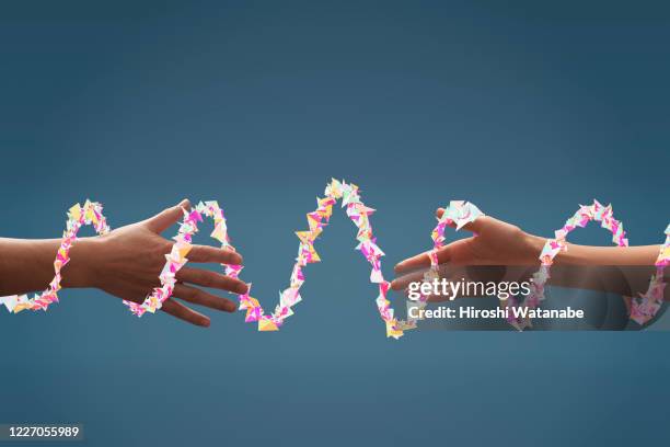 two hands seem to reach together with light trails - composite bonding stock pictures, royalty-free photos & images