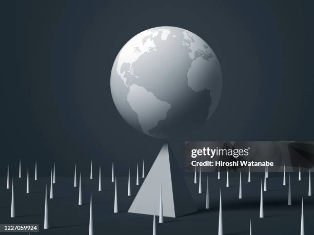 the earth on a triangular pyramid and many needles around it - global crisis stock pictures, royalty-free photos & images