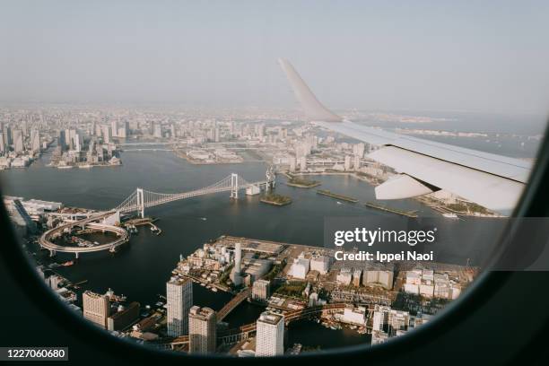 tokyo skyline with rainbow bridge from airplane window - aeroplane window stockfoto's en -beelden