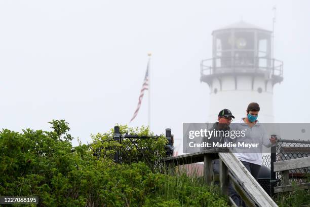 People walk on Lighthouse Beach in on May 25, 2020 in Chatham, Massachusetts. Massachusetts has begun Phase 1 of reopening after the coronavirus...