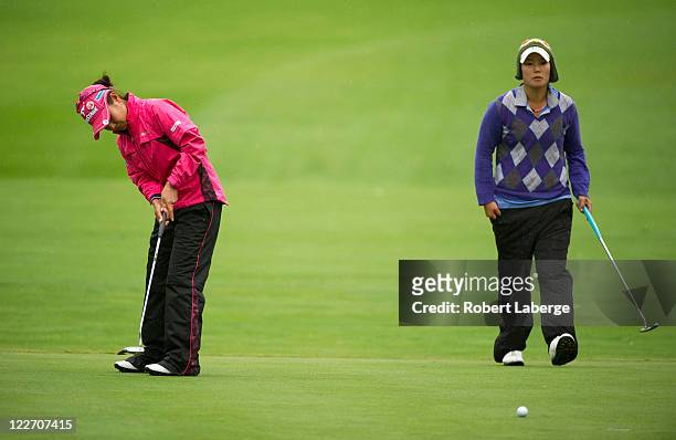 Ai Miyazato of Japan attempts a putt on the 14th hole as Tiffany Joh looks on during the final round of the CN Canadian Women's Open at the Hillsdale...