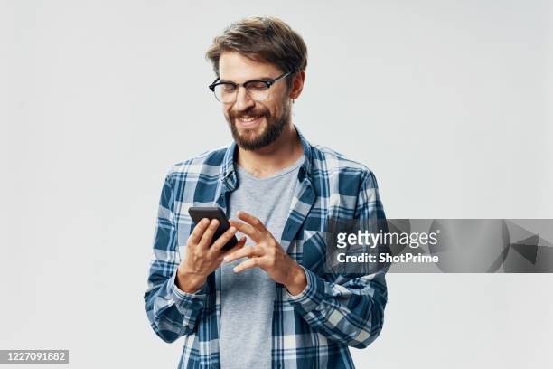hipster in casual wear is using his smartphone with a smile. - executive smile pointing bildbanksfoton och bilder