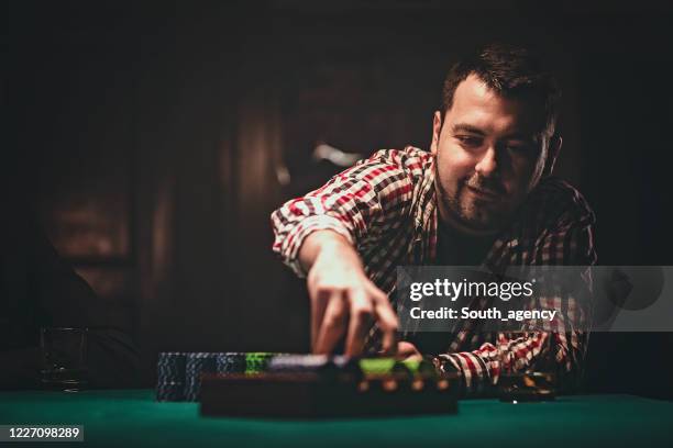 one man playing poker late by night - gambling table stock pictures, royalty-free photos & images